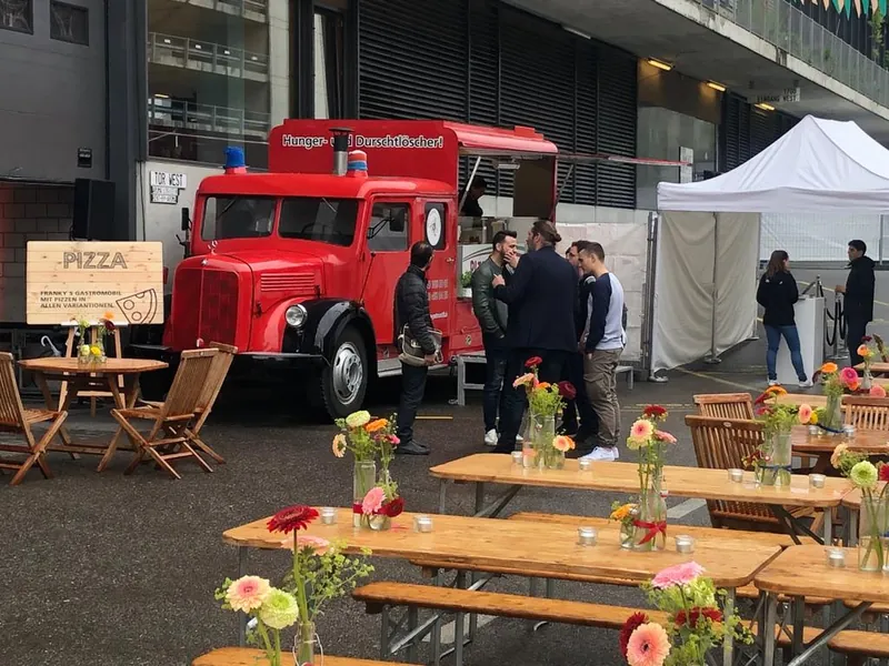 Lange Festtische mit Blumen vor dem Feuerwehrauto